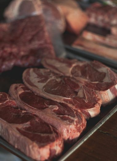 Fresh raw beef cuts on a tray, perfect for cooking enthusiasts and food markets.